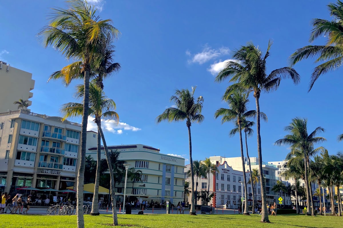 White concrete condo building near palm trees on a sunny Florida day